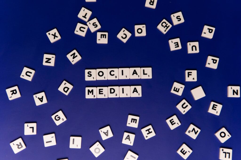Réseaux sociaux vs site web Scrabble tiles spelling 'Social Media' on a blue background, ideal for digital marketing themes.